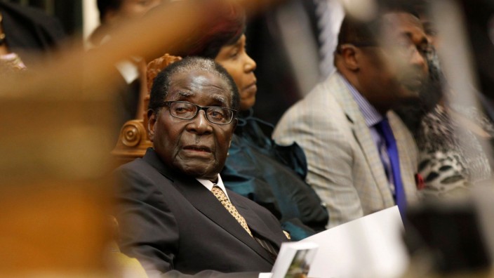 FILE PHOTO -  File photo of Zimbabwe's President Mugabe listening as FM Chinamasa presents the country's 2014 National Budget to Parliament in Harare