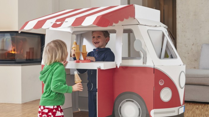 Brother and sister with popsicles and model ice cream van in living room model released Symbolfoto p