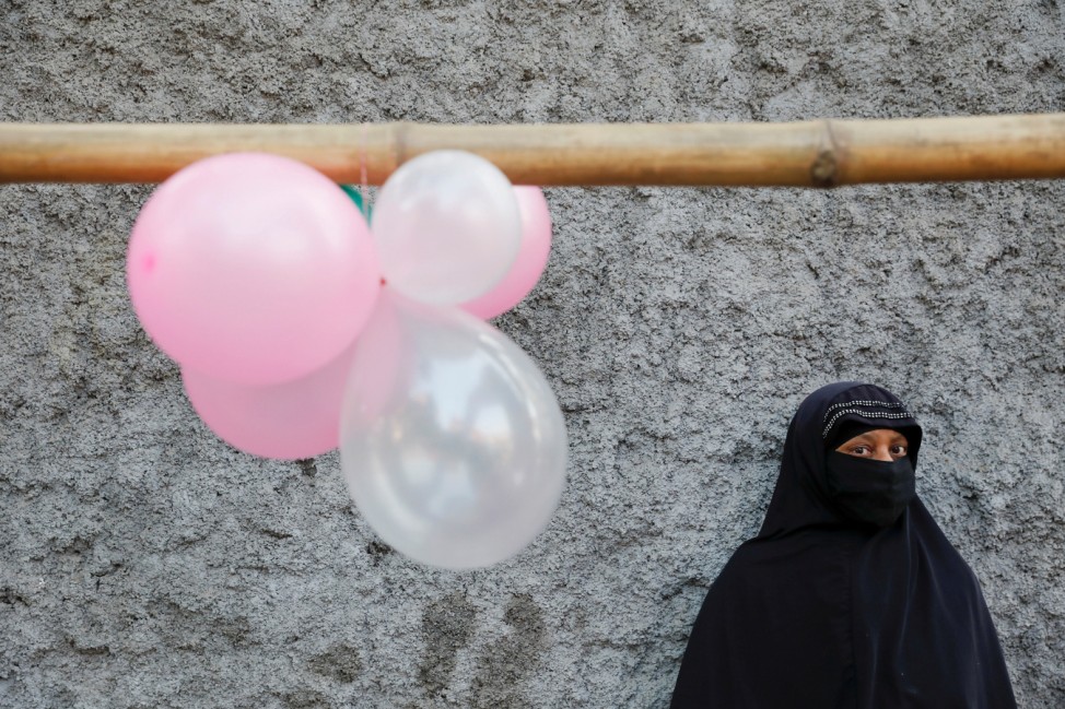 A woman stands under balloons decorating an alley near the Holy Rosary church before Pope Francis arrives there, in Dhaka