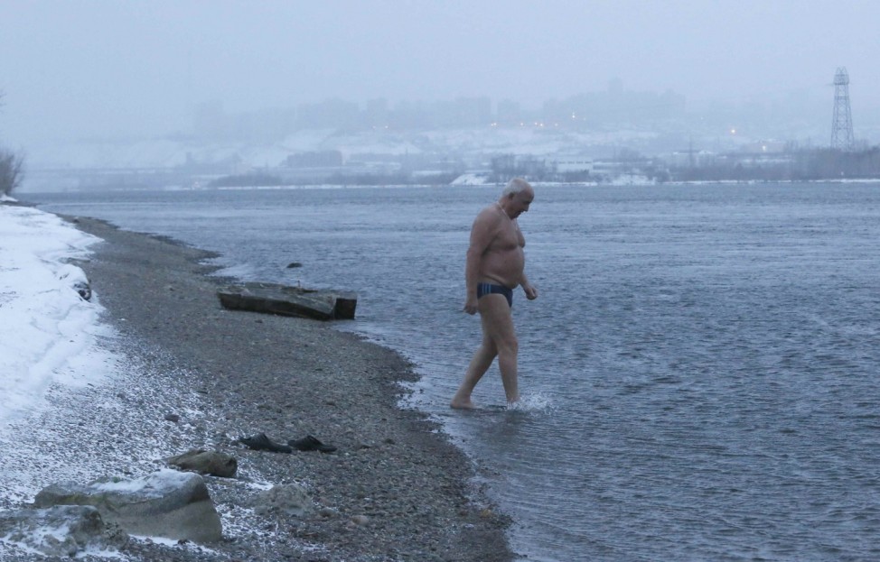 A member of the Cryophile winter swimming club walks into the icy waters of the Yenisei River in the Siberian city of Krasnoyarsk