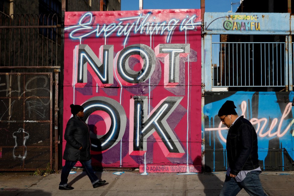 People walk by street art in the Brooklyn borough of New York City