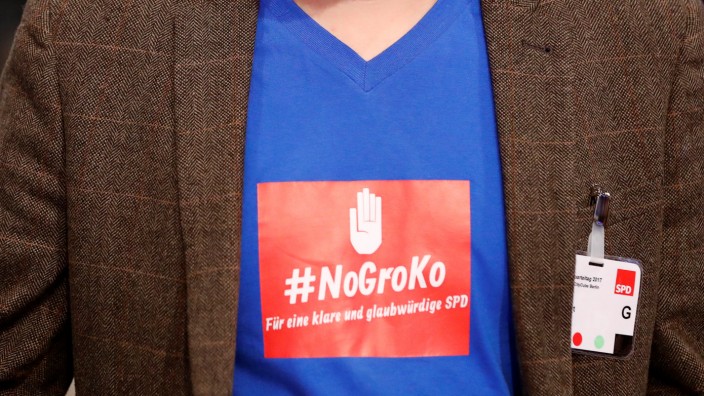 A delegate wears a sticker reading 'No Grand Coalition. For a clear and credible SPD' during an SPD party convention in Berlin
