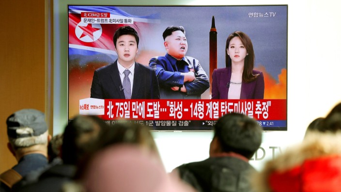FILE PHOTO: People watch a TV broadcasting a news report on North Korea firing what appeared to be an intercontinental ballistic missile (ICBM) that landed close to Japan, in Seoul