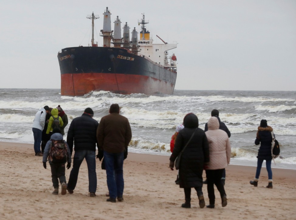 People look on stranded cargo ship Ocean Crown in Klaipeda