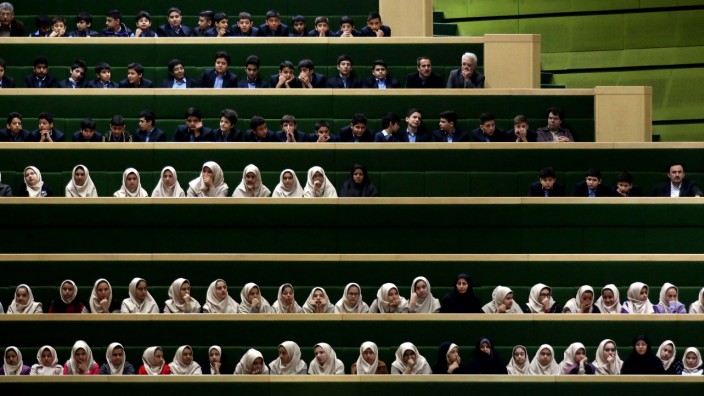 Iran: Iranische Schüler besuchen eine Parlamentsdebatte in Teheran: Irans politisches System ist ein Zwitterwesen aus Demokratie und Theokratie.