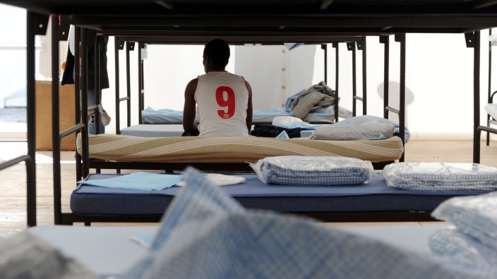 Asylpolitik: Ein Flüchtling sitzt auf einem Bett in einer Unterkunft in München.