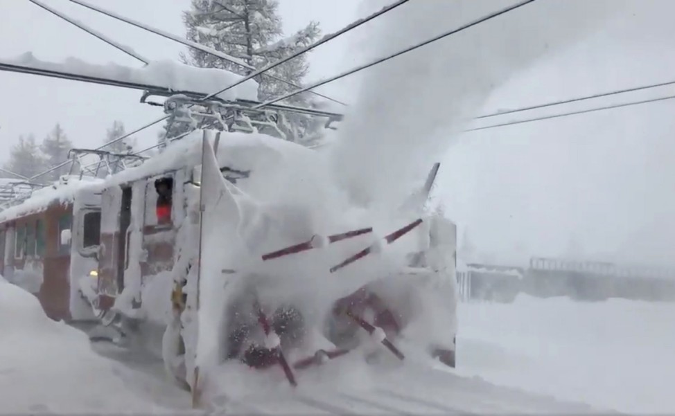 A train clears snow from a railway in Zermatt resort