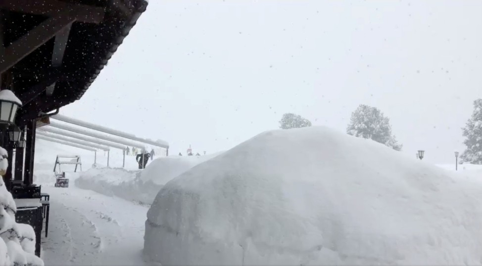 A man shovels snow at a hotel in Zermatt resort