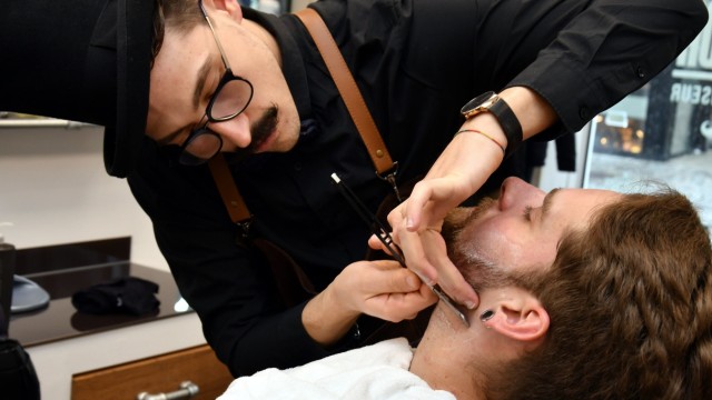 Die Geschichte eines kreativen Italo-Bayern: Der Barbier Giuseppe Carlucci macht Präzisionsarbeit mit dem Rasiermesser, hier bei seinem Kunden Jonas Ringling.