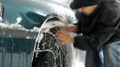 Stromausfälle und Massenkarambolagen: Gut gerüstet: Ein Autofahrer in Tacoma im US-Bundesstaat Washington überprüft den Sitz seiner Schneeketten.