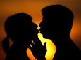 Ein Paar küsst sich bei Sonnenuntergang