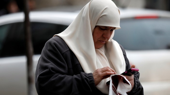 Palestinian woman uses her mobile phone in the West Bank city of Ramallah