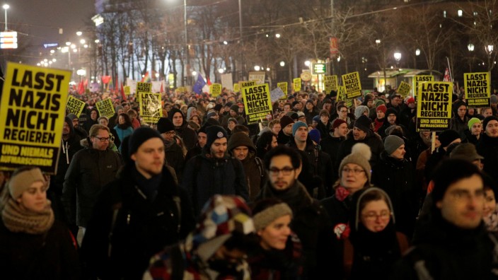 Protesters hold signs during an anti-government demonstration in Vienna