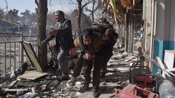 Kampf gegen Extremisten: Sprengstoff im Krankenwagen: Nach einem Anschlag im Herzen von Kabul am Wochenende tragen freiwillige einen Verletzten davon.