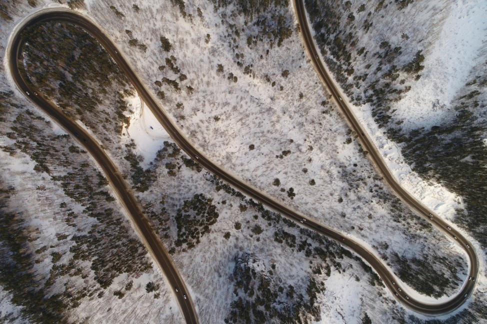 An aerial view shows vehicles driving along the R257 'Yenisei' federal highway in the Siberian Taiga area outside Krasnoyarsk
