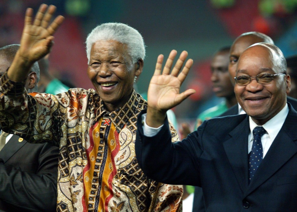 Former South African President Nelson Mandela and deputy President Jacob Zuma waves to soccer fans in Johannesburg