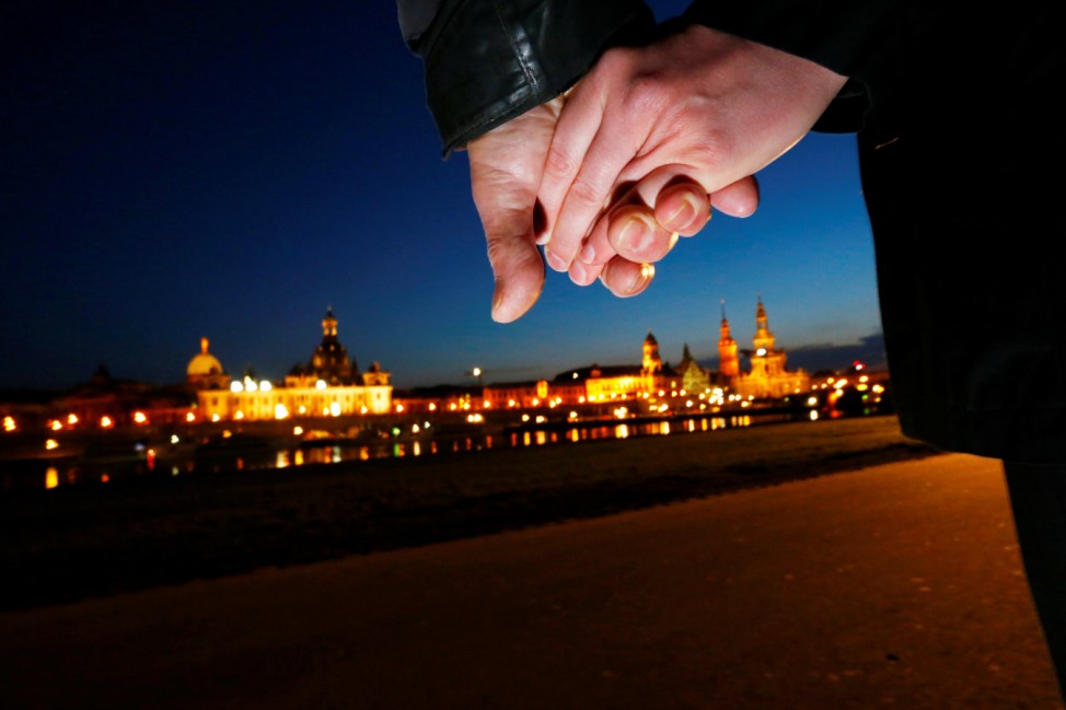 People hold hands during the human chain along the Elbe river in front of the Dresden historical city center in Dresden to commemorate the World War II bombing of the city