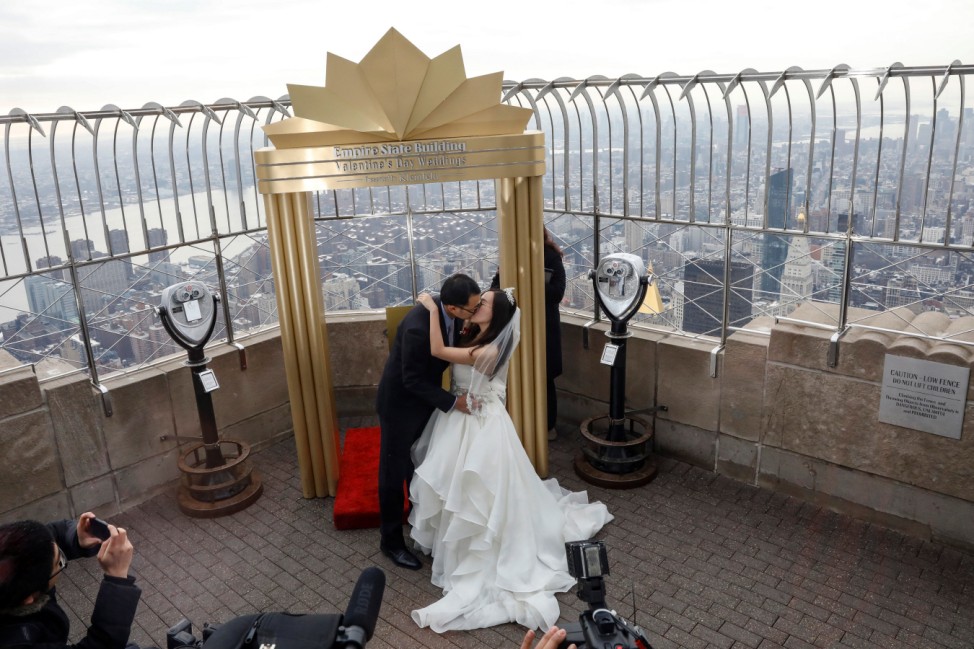 An Wang and Wei Cui kiss after exchanging wedding vows at their Valentine's Day wedding ceremony at the top of the Empire State Building in New York