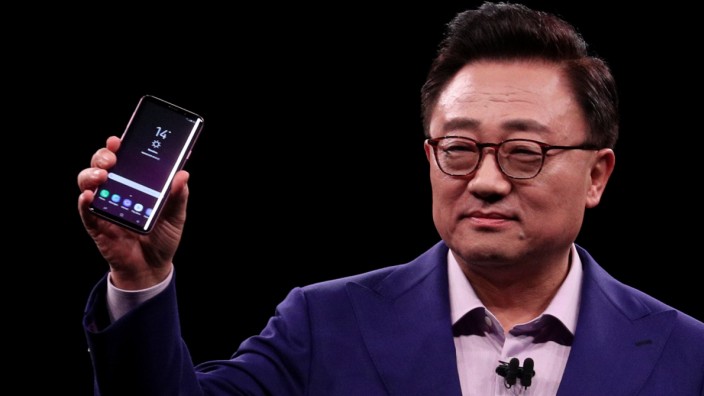 DJ Koh, Samsung's Mobile Communications Business president, holds up new S9Plus devicesduring presentation ceremony in Barcelona