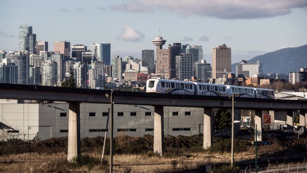 Ein Skytrain fährt vor der Skyline von Vancouver