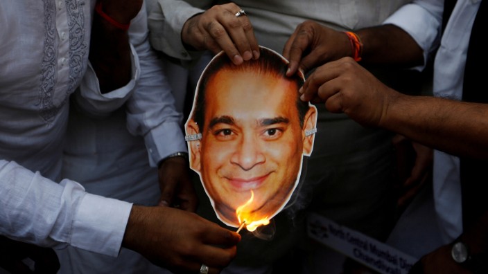 FILE PHOTO: Activists of the youth wing of India's main opposition Congress party burn a cut-out with an image of billionaire jeweller Nirav Modi during a protest in Mumbai