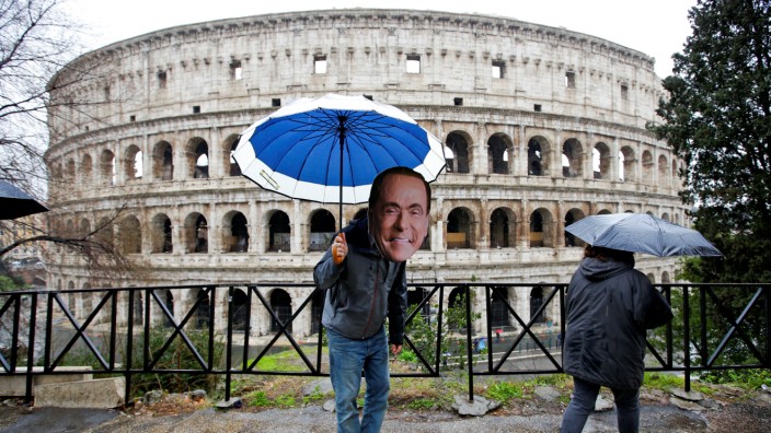 An activist wearing a mask of Forza Italia party leader Silvio Berlusconi poses during a tour, the day after Italy's parliamentary election, in Rome