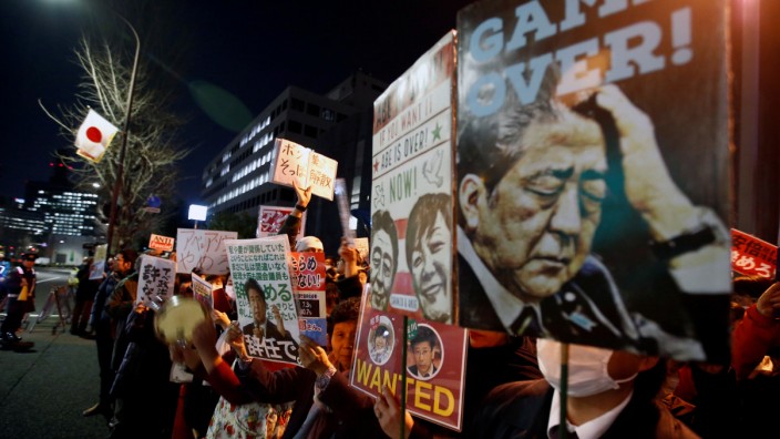 Protesters shout slogans with placards denouncing Japanese Prime Minister Shinzo Abe at a rally in Tokyo