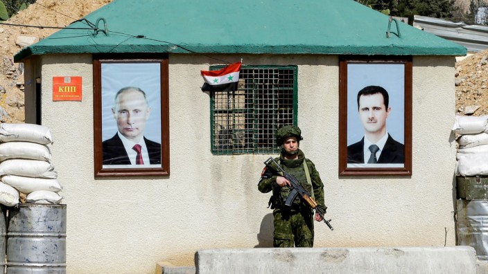 Großbritannien und Russland: Bilder von Russlands Präsident Putin und Syriens Machthaber Assad an einem Checkpoint nahe Damaskus.