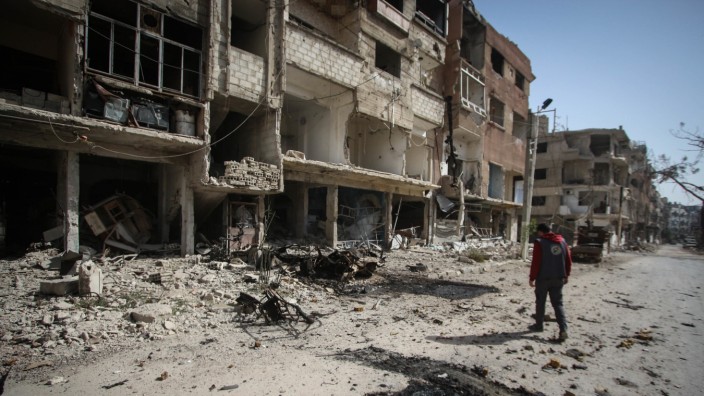 Krieg in Syrien: Ein Mann geht an zerstörten Häusern in Ost-Ghouta vorbei.