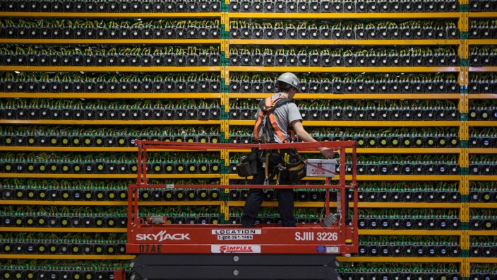 Kryptografie: Ein Techniker inspiziert eine Anlage zum Schürfen von Bitcoins. Diese Krypto-Währung basiert auf der Blockchain-Technologie.