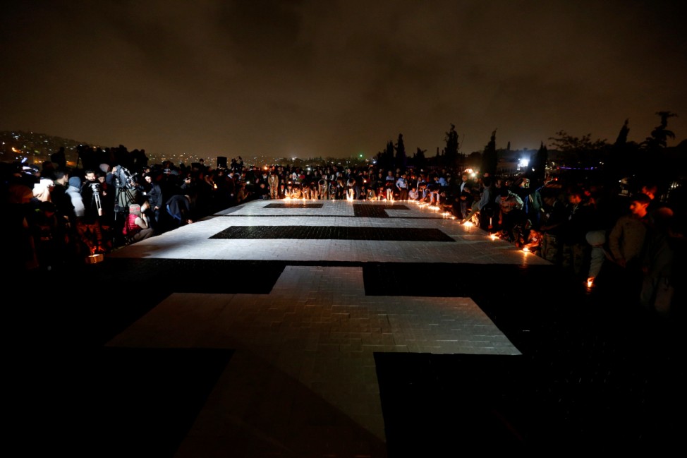 People light candles after they set a Guinness World Record by creating the world's largest candle mosaic at Amman Citadel