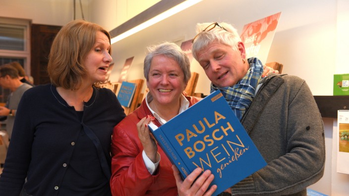 "Wein genießen": Schwere Kost: 240 Seiten hat das neue Buch von Paula Bosch (Mitte). Hier zeigt sie es den Ladenbesitzern Helga Hedewig und Walter Zimmermann.