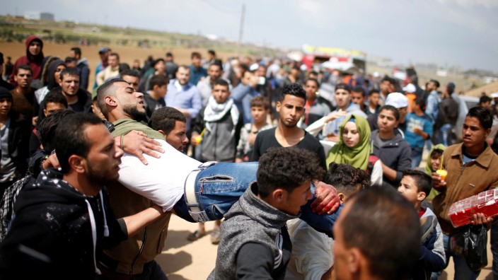 Wounded Palestinian is evacuated during clashes with Israeli troops, during a tent city protest along the Israel border with Gaza, demanding the right to return to their homeland, east of Gaza City