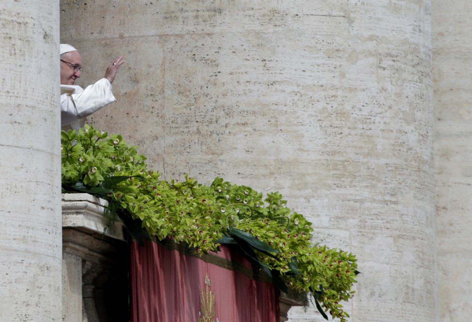 Pope Francis waves before delivering his Easter message in the Urbi et Orbi (to the city and the world) address from the balcony overlooking St. Peter's Square at the Vatican