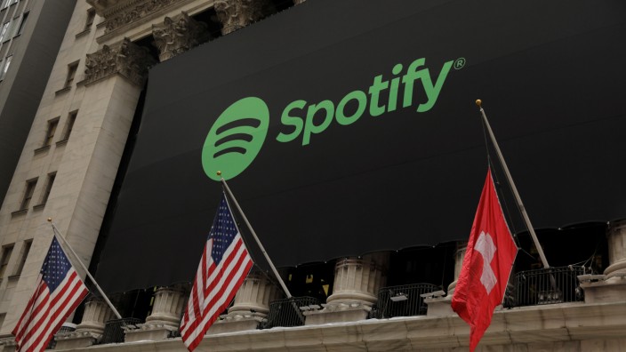 The Spotify logo hangs on the facade of the New York Stock Exchange with U.S. and a Swiss flag as the company lists it's stock with a direct listing in New York