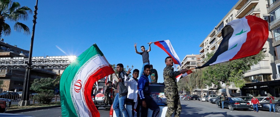 Syrien: Inszenierte Empörung: Demonstranten schwenken nach den Angriffen der Alliierten iranische, syrische und russische Fahnen in Damaskus.
