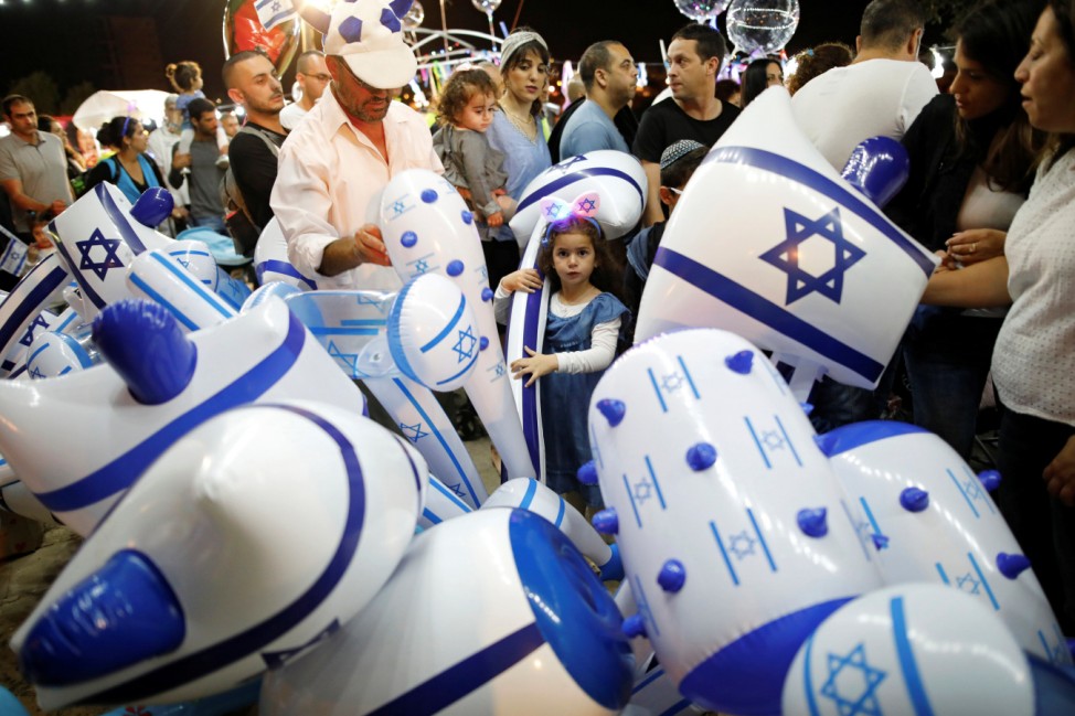 An Israeli girl plays with an inflatable hammer during celebrations marking Israel's 70th Independence Day in the southern city of Ashkelon