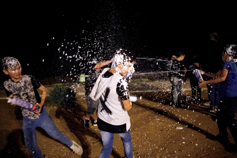 Israeli youth play with foam spray during celebrations marking Israel's 70th Independence Day in the southern city of Ashkelon