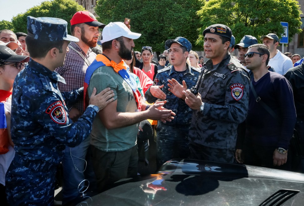 Armenian opposition supporters argue with police officers as they block a road after protest movement leader Nikol Pashinyan announced a nationwide campaign of civil disobedience in Yerevan