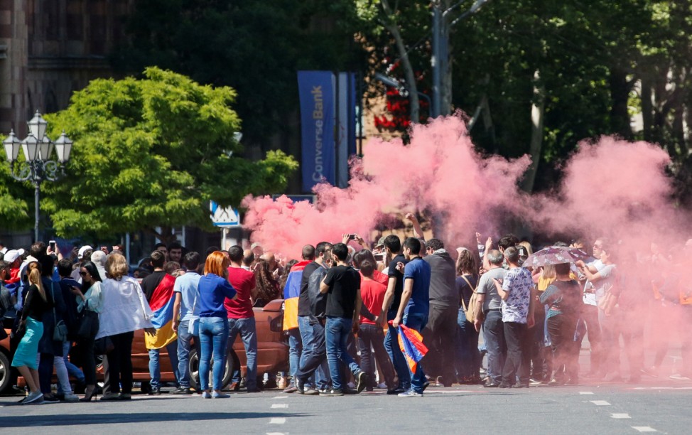 Armenian opposition supporters light a flare as they block a road, after protest movement leader Nikol Pashinyan announced a nationwide campaign of civil disobedience in Yerevan