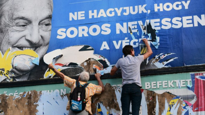 Stiftungen: Propaganda gegen den jüdischen Investor Soros: Aktivisten versuchen das Plakat der ungarischen Regierung wieder abzureißen.
