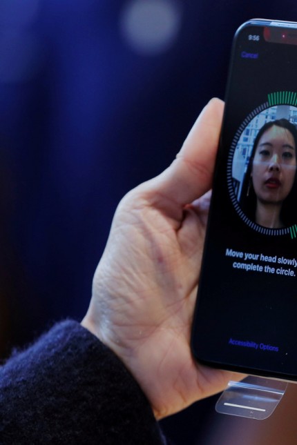 FILE PHOTO: A woman sets up facial recognition on her Apple iPhone X at an Apple store in New York