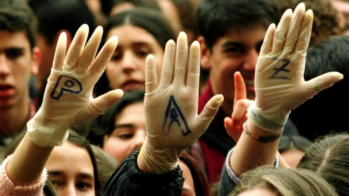 FILE PHOTO: Demonstrators raise their hands showing the letters for 'Peace' written on their white gloves as they protest against the Basque separatist guerrilla group ETA in front of city hall in Seville
