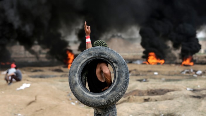 Gaza-Proteste: Ein protestierender Palästinenser trägt an der Gaza-Grenze einen Autoreifen.