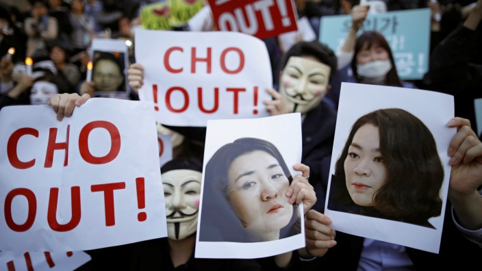 People hold portraits depicting Cho Hyun-ah and Cho Hyun-min, daughters of Korean Air Lines' chairman Cho Yang-ho as they take part in a protest against the abuse of power by them, in central Seoul
