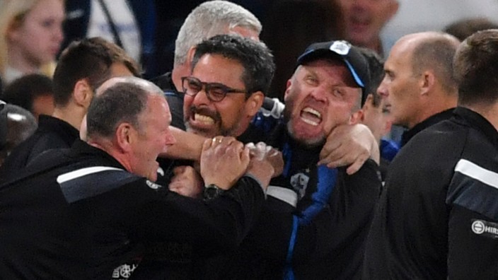 England: Sie haben ihn zum Drücken gerne: Huddersfields Trainer David Wagner (in der Mitte) wird von seinem Trainerteam robust geherzt.
