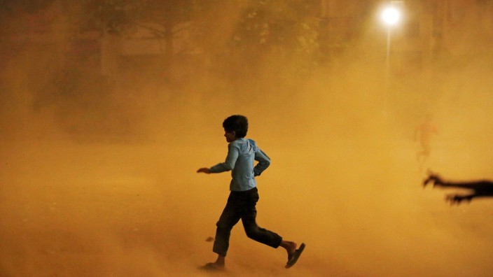 A boy runs for cover during a dust storm in New Delhi