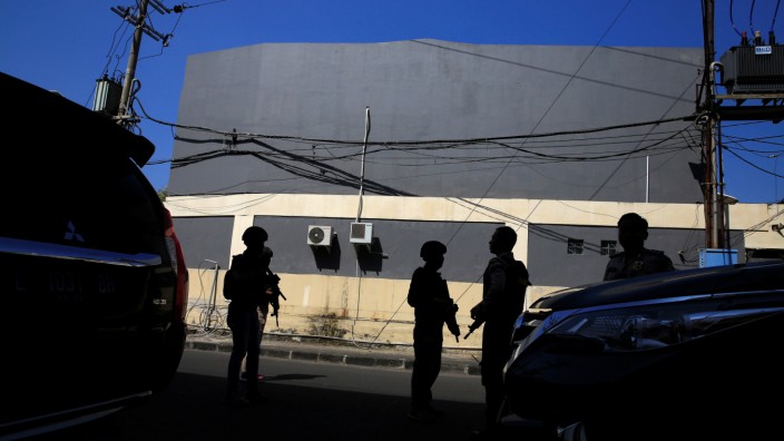 Anti-terror policemen stand guard following a bomb blast at a police office in Surabaya