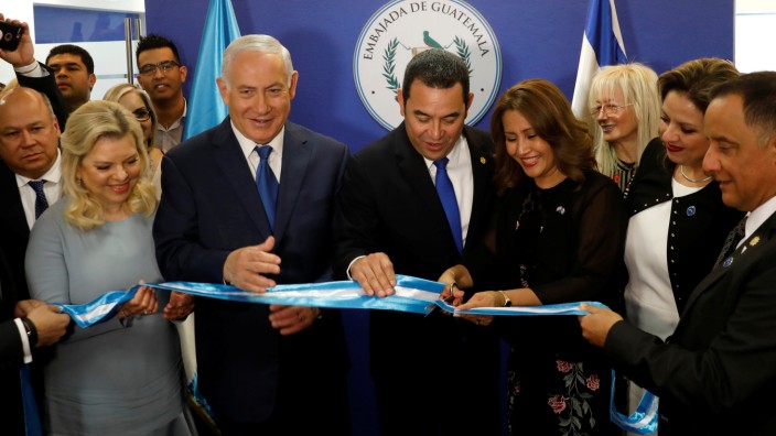 Hilda Patricia Marroquin, the wife of Guatemalan President Jimmy Morales, cuts the ribbon during the dedication ceremony of the embassy of Guatemala in Jerusalem, as she stands with Guatemalan President Jimmy Morales, Israeli Prime Minister Benjamin Netan
