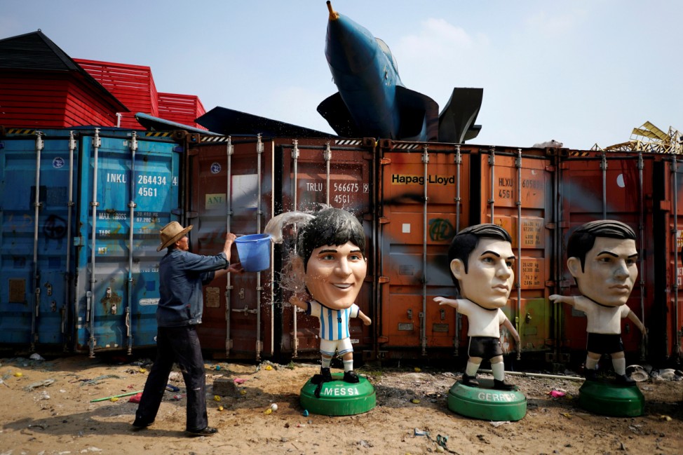 A worker cleans a Lionel Messi figure at a small factory in the outskirts of Shanghai